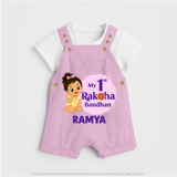 My First Raksha Bandhan Baby Girl Dungaree – girl sitting with Rakhi theme. - BABY PINK - 0 - 5 Months Old (Chest 18")