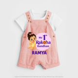 My First Raksha Bandhan Baby Girl Dungaree – girl sitting with Rakhi theme. - PEACH - 0 - 5 Months Old (Chest 18")