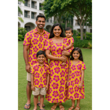 Indian family in coordinated yellow and magenta floral print cotton outfits – mom, dad, son, daughter, and baby in tropical-themed matching clothing