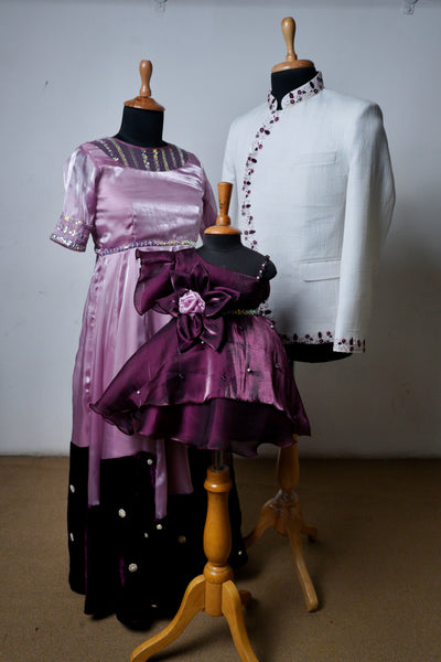Coordinated family outfit set in lavender and plum with embellished gown, embroidered bandhgala, and floral baby frock