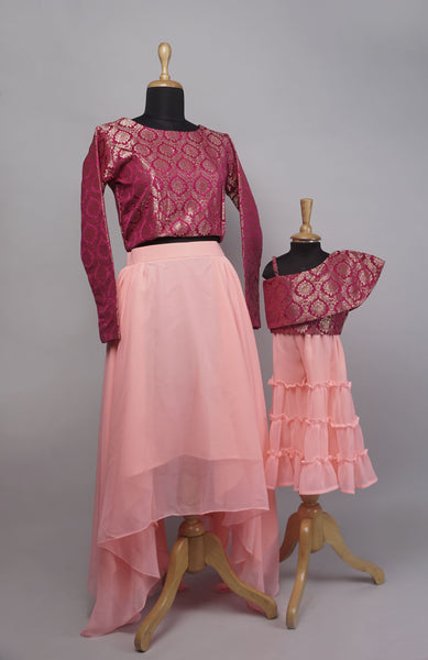 Mother and Daughter Matching Outfit Set featuring a wine brocade top and layered pink skirt for mom, and a one-shoulder brocade top with pink layered skirt for daughter.