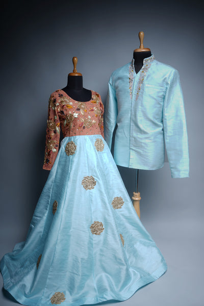 Couple ethnic wear set with aqua blue lehenga and peach embroidered blouse paired with aqua kurta for men.