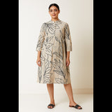 Woman wearing a natural beige leaf-printed A-line midi dress with 3/4th sleeves and mandarin collar