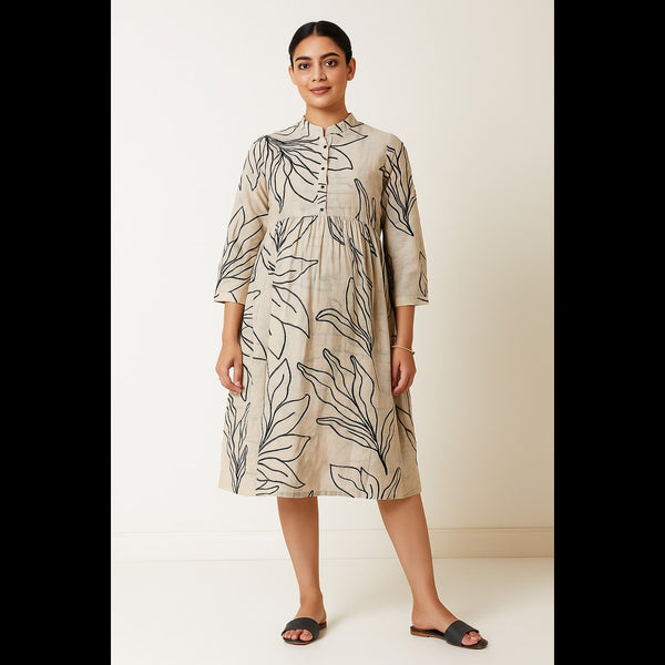 Woman wearing a natural beige leaf-printed A-line midi dress with 3/4th sleeves and mandarin collar