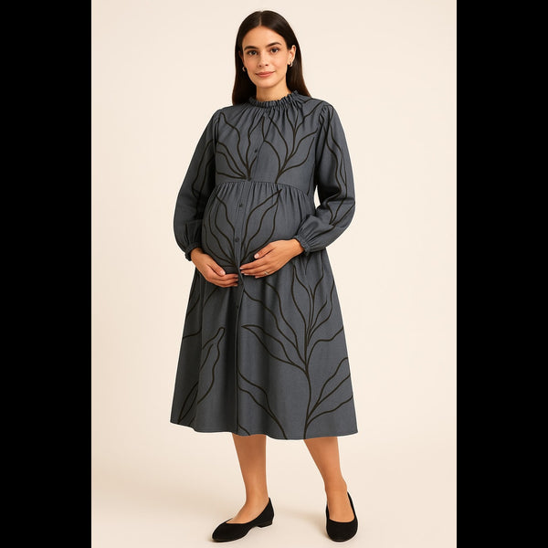 Pregnant woman in charcoal grey maternity dress with leaf print and full sleeves