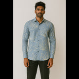 Man wearing a sky blue embroidered leaf-pattern shirt paired with black trousers