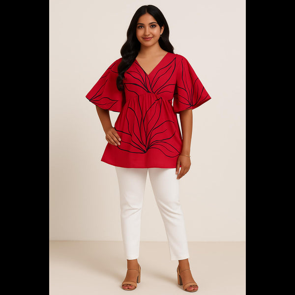 Indian woman wearing a red floral print top with flared sleeves and white pants