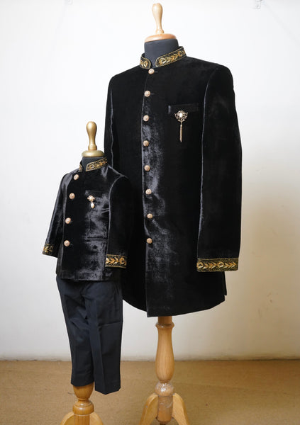 Father and son matching black velvet sherwani set with golden embroidery and ornamental brooch