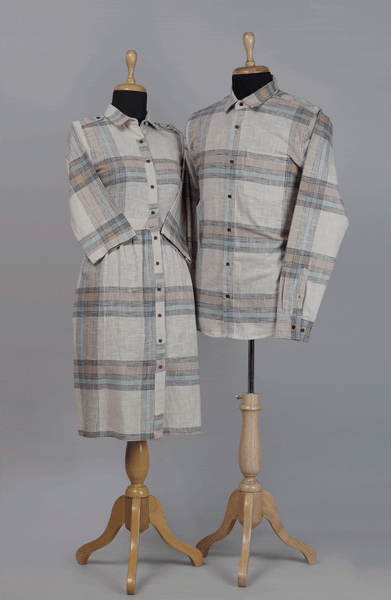 Couple wearing beige-grey checked twinning outfits — woman in button-down midi dress & man in matching full-sleeve shirt.