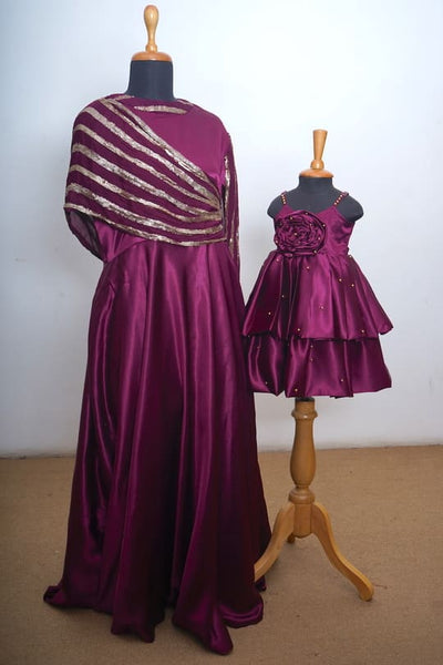 Regal maroon satin matching gown set for mom and daughter with gold dupatta detailing and layered baby frock - festive and wedding wear.