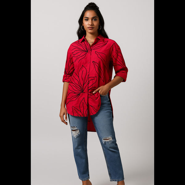 Woman wearing bold red floral oversized shirt with ripped jeans – front view
