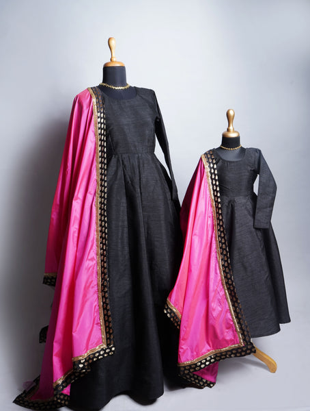 Mom and daughter in black ethnic gowns with pink dupattas and gold lace - matching festive outfit set
