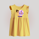 My First Raksha Bandhan Baby Girl Baby Frock – girl sitting with Rakhi theme. - PASTEL YELLOW - 0 - 3 Months Old (Chest 17")