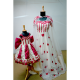 Mother and daughter wearing matching heart-themed gowns in red and white with satin and net details.