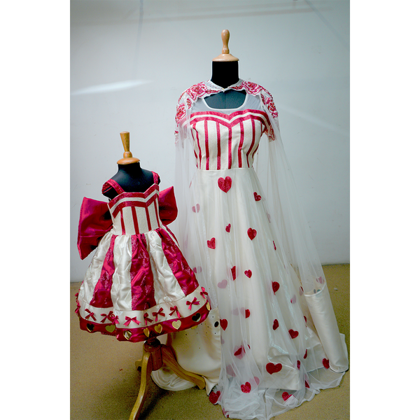 Mother and daughter wearing matching heart-themed gowns in red and white with satin and net details.