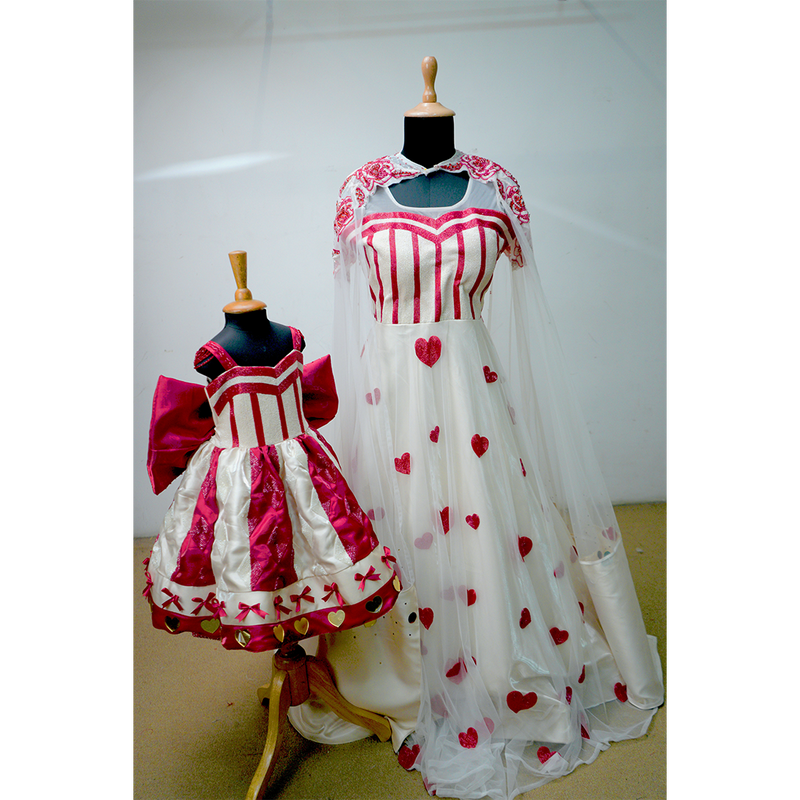 Mother and daughter wearing matching heart-themed gowns in red and white with satin and net details.