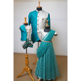 Dad, son, and daughter wearing matching teal and ivory traditional Indian outfits with embroidered details