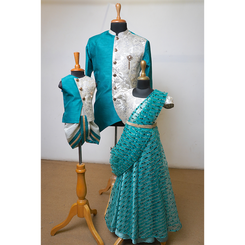 Dad, son, and daughter wearing matching teal and ivory traditional Indian outfits with embroidered details