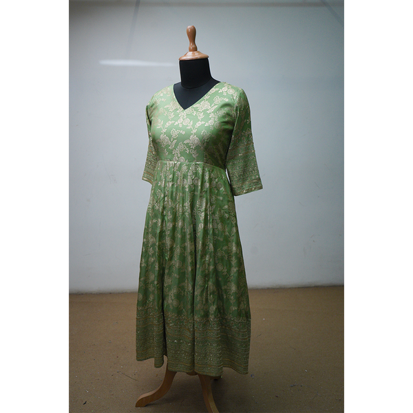 Green brocade ethnic dress with golden floral motifs and elbow-length sleeves