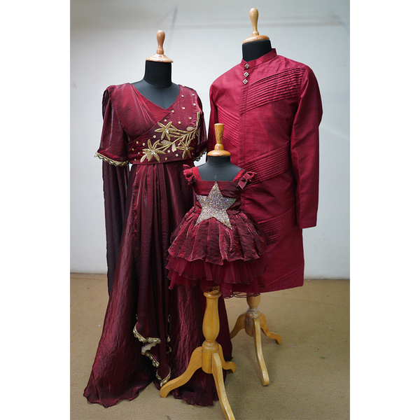 Burgundy family outfit set featuring embroidered gown for mom, kurta for dad, and glittery star frock for baby girl
