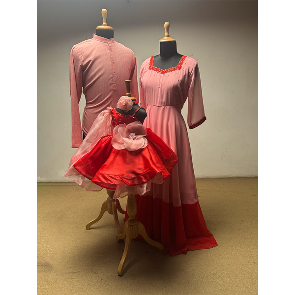 Family combo outfit in pink and red featuring dad’s kurta, mom’s long gown, and baby girl’s floral frock